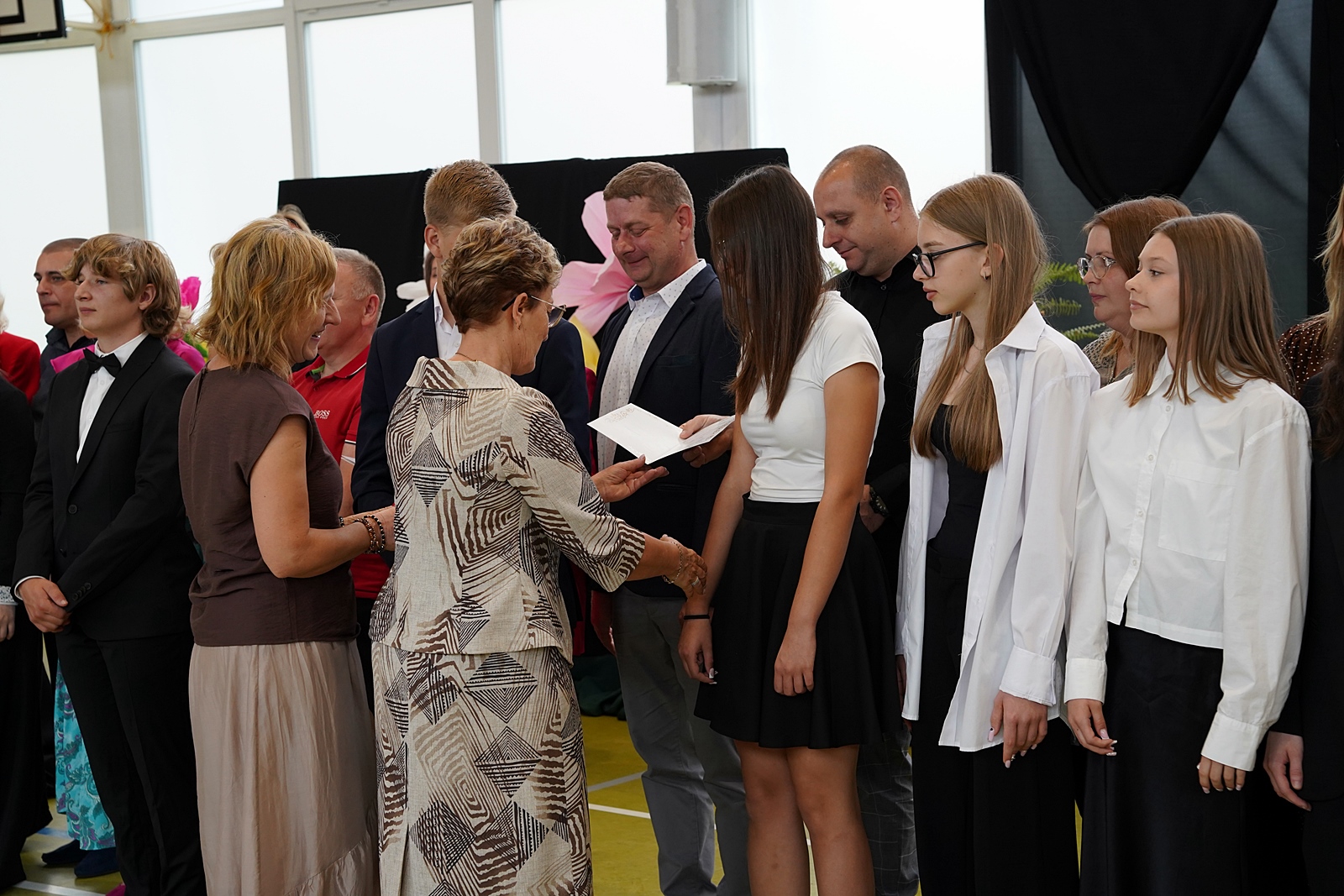 Dyrektor wręcza list gratulacyjny.