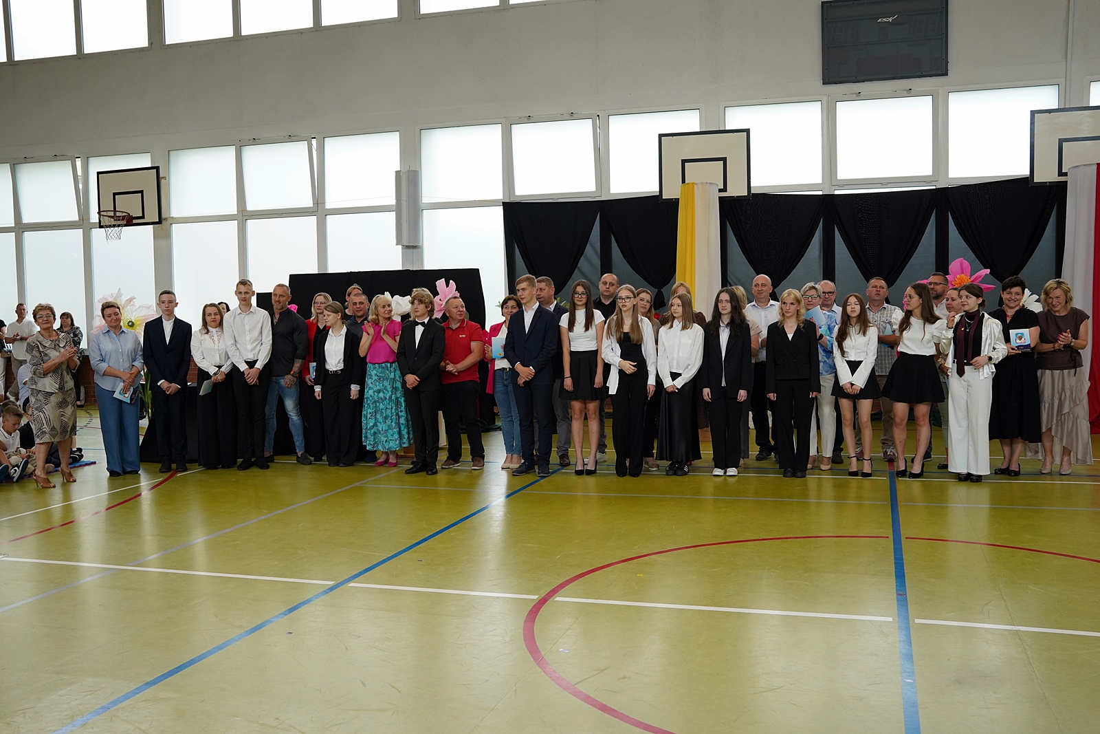 Wspólne zdjęcie uczniów i rodziców, którzy otrzymali listy gratulacyjne. Między nimi dyrekcja szkoły i wychowawcy klas.