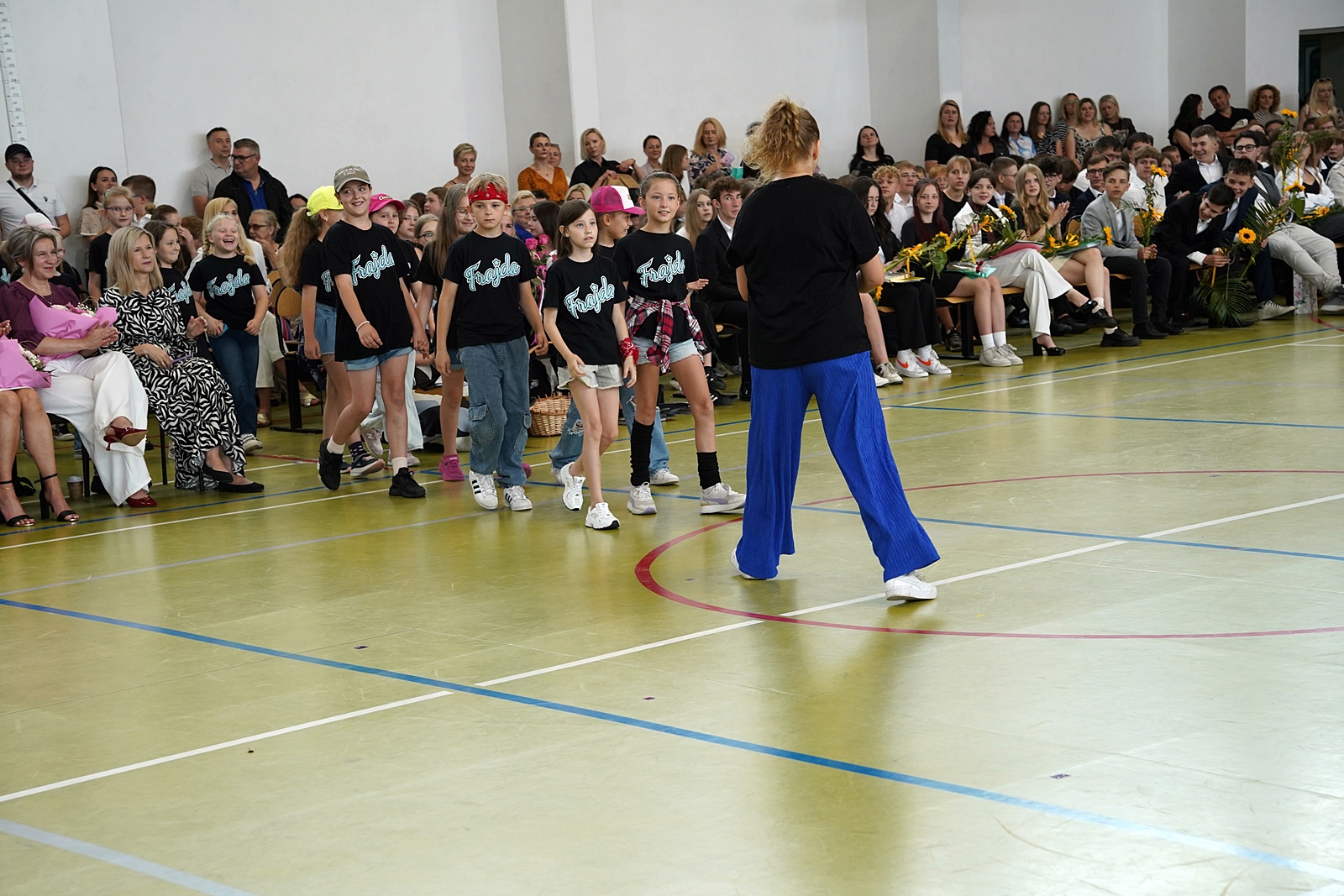 Grupa zespołu "Frajda" wchodzi na salę gimnastyczną.