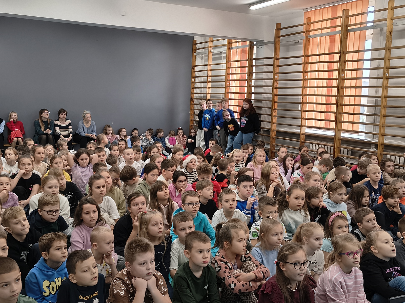Duża grupa osób zgromadzonych w sali gimnastycznej.