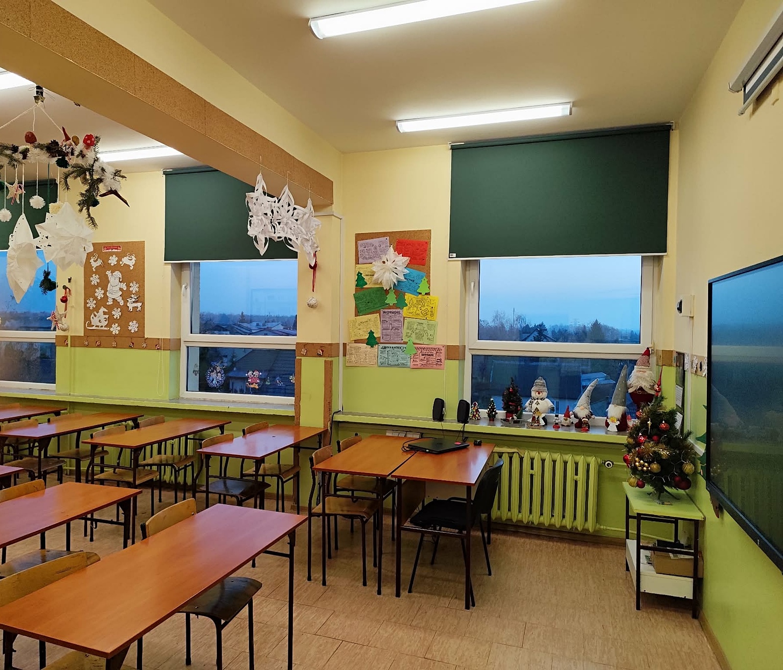 Udekorowana świątecznie sala lekcyjna: białe gwiazdy, choinki, bałwanki.