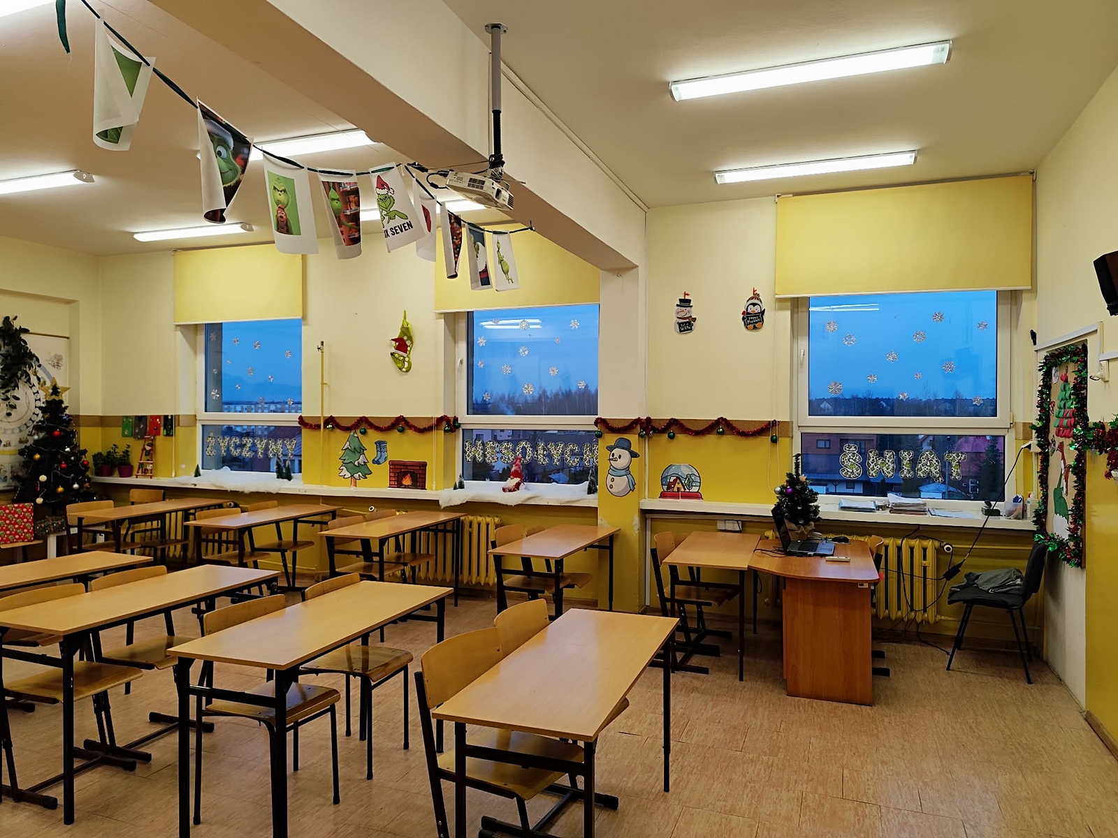 Udekorowana świątecznie sala lekcyjna: na oknach napis "Życzymy wesołych świąt".