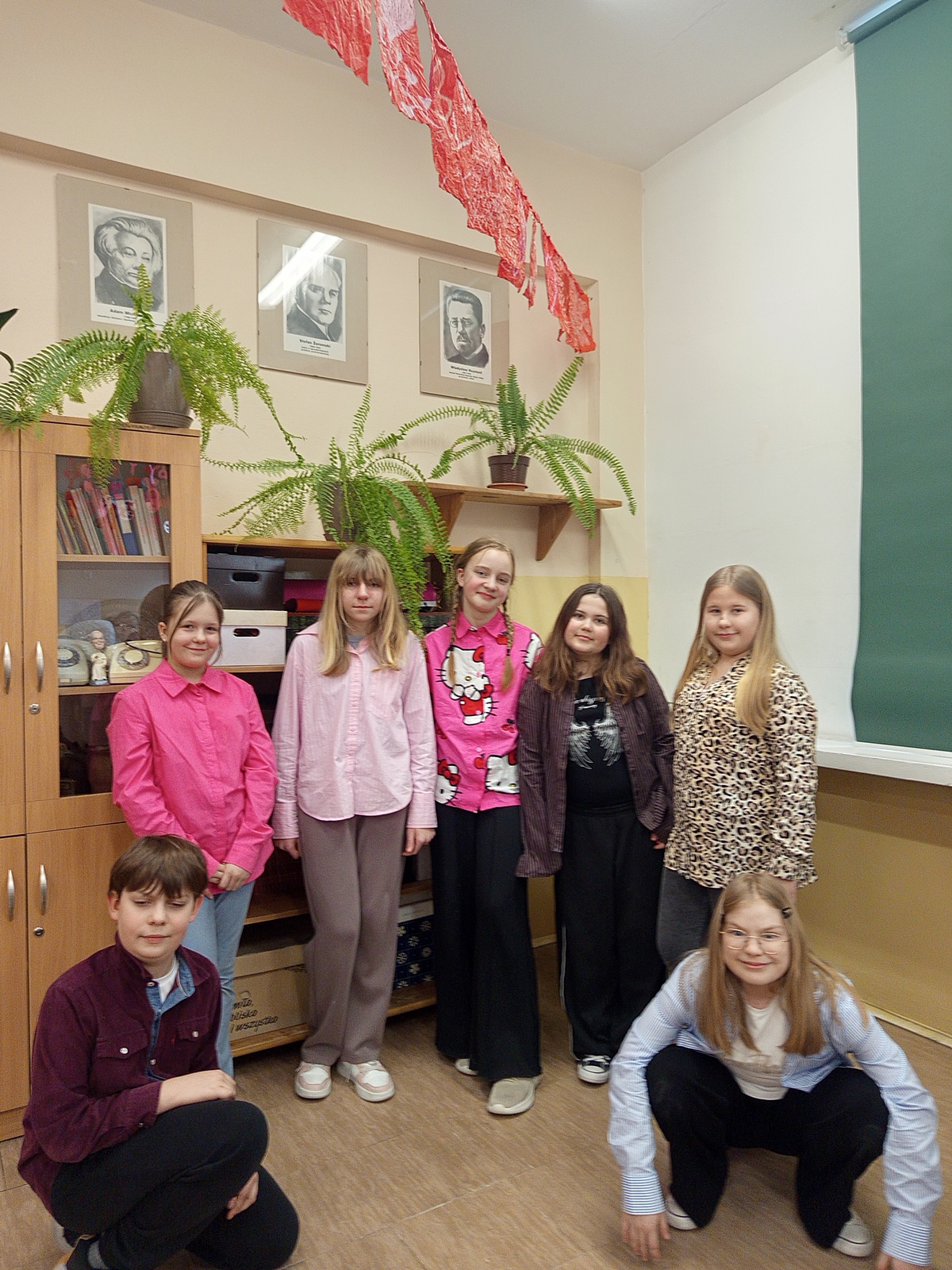 Grupa siedmiu uśmiechniętych uczniów pozujących w kolorowych koszulach.