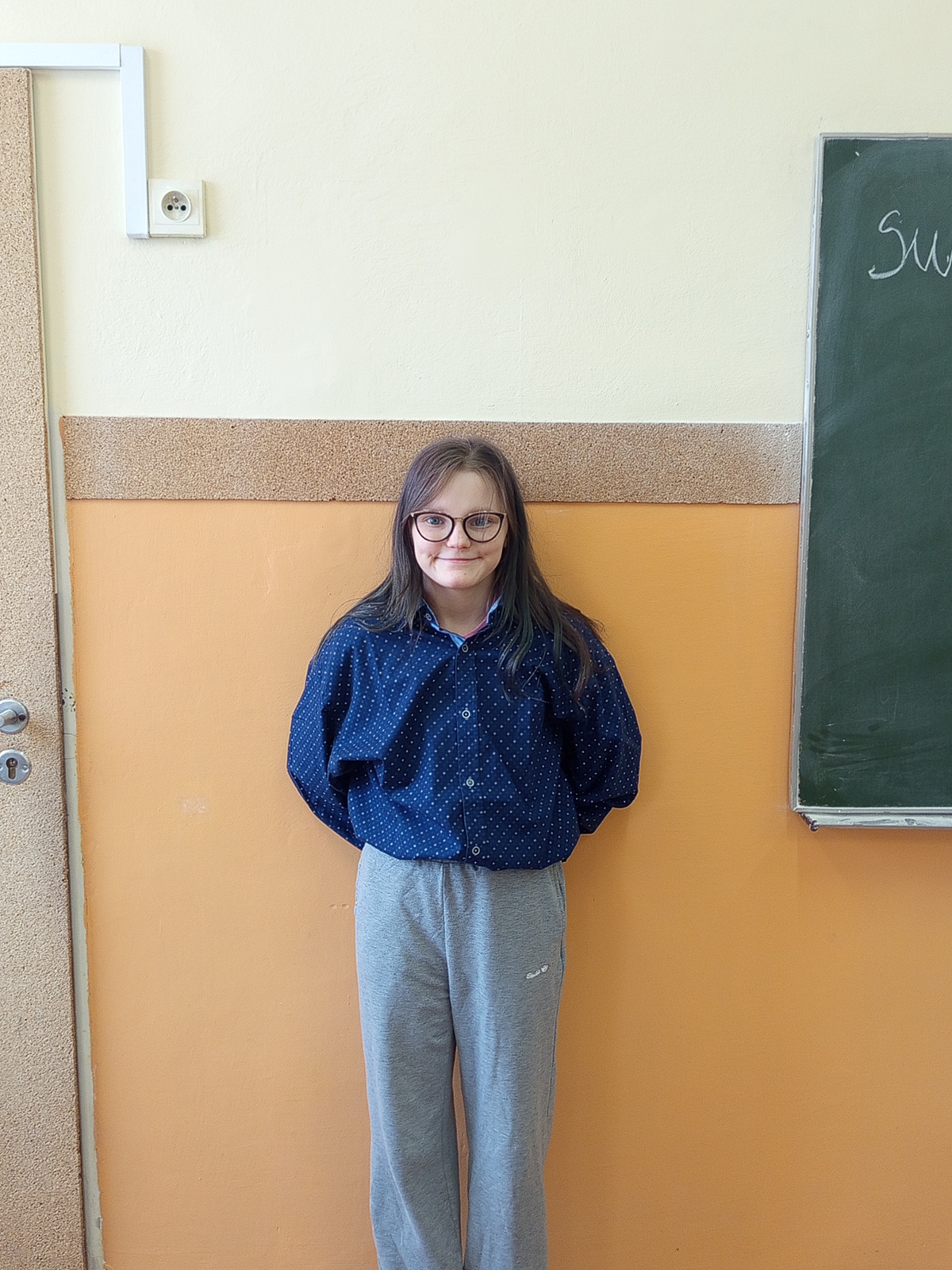 Uśmiechnięta uczennica pozującą do zdjęcia w koszuli (szkolne obchody Dnia Koszuli).